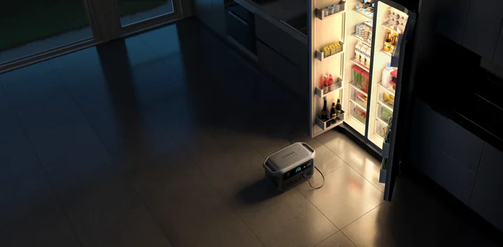 Anker SOLIX C2000 Gen 2 beside an open refrigerator in a dark kitchen.
